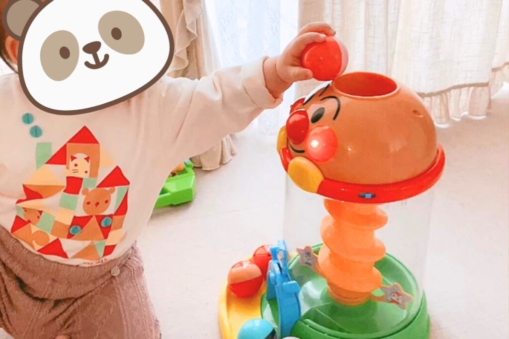 子供がアンパンマンの玉入れオモチャで遊んでいる